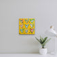 LEMON TREE. Original mixed media on canvas with vintage cookbook and hearts. Hanging on bright white wall with white desk, lamp, and plant in foreground.